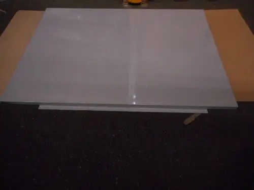 Graue, flache Platte auf Kartonunterlage, ohne sichtbare Beschriftungen, in einem Raum, möglicherweise zum Einsatz bei Remeha Produkten.